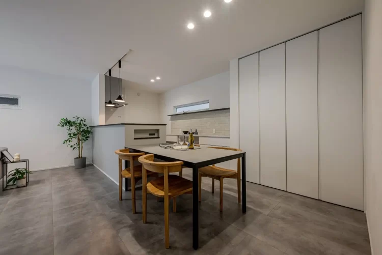 [キッチン インテリア] ペンダントライトとタイル調アクセントクロスが映える、スタイリッシュな対面式キッチン